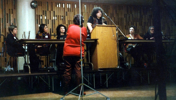 1986. Andrea Dworkin speaks at the March 1, 1986 New York City Custody Speak Out. On stage with her, from the left, are Noreen Connell, Toi Derricotte, EM Broner, Ti-Grace Atkinson, and Kate Millett.