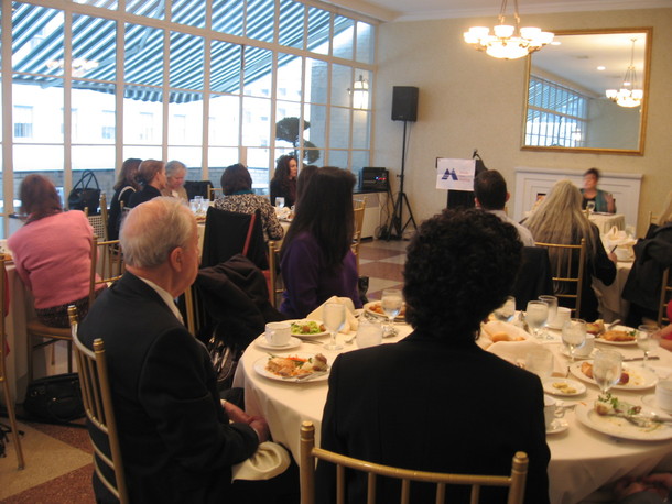 Attendees listening to the talk and enjoying their luncheon.